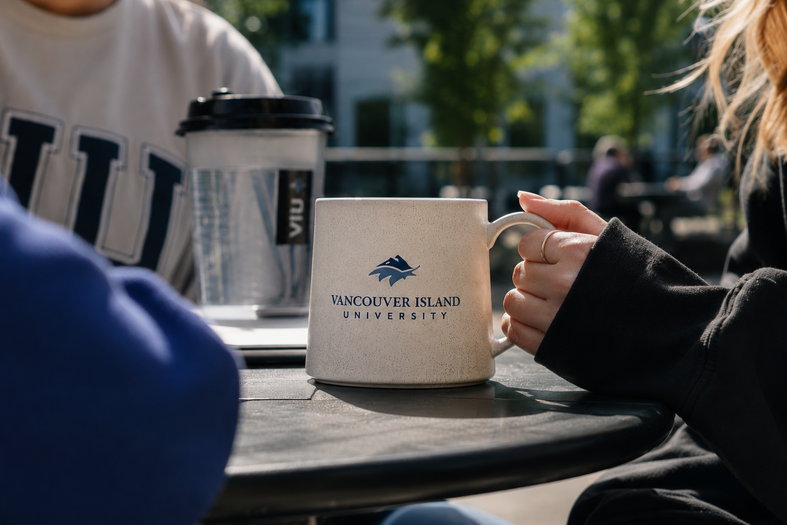 Vancouver Island University coffee mug on an outdoor campus table